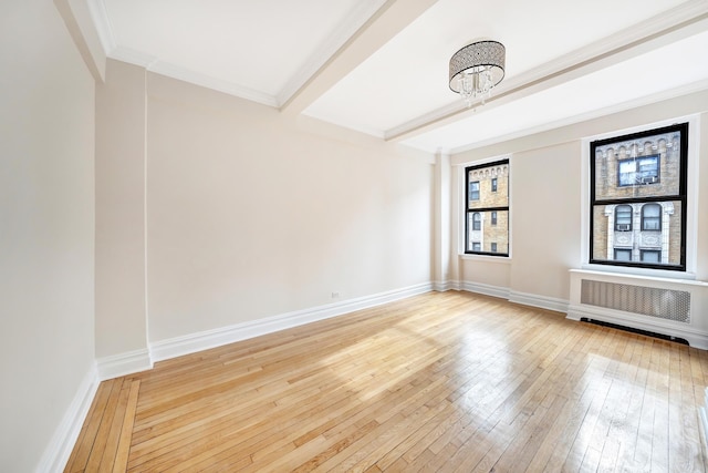 spare room featuring radiator, baseboards, beamed ceiling, ornamental molding, and hardwood / wood-style floors