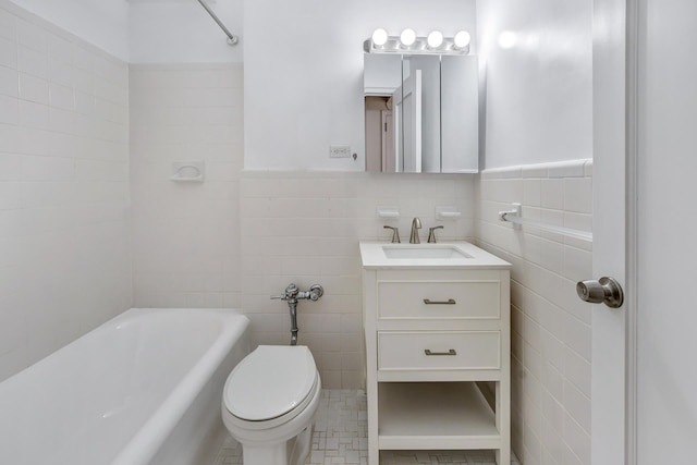 bathroom featuring vanity, tile walls, toilet, and wainscoting