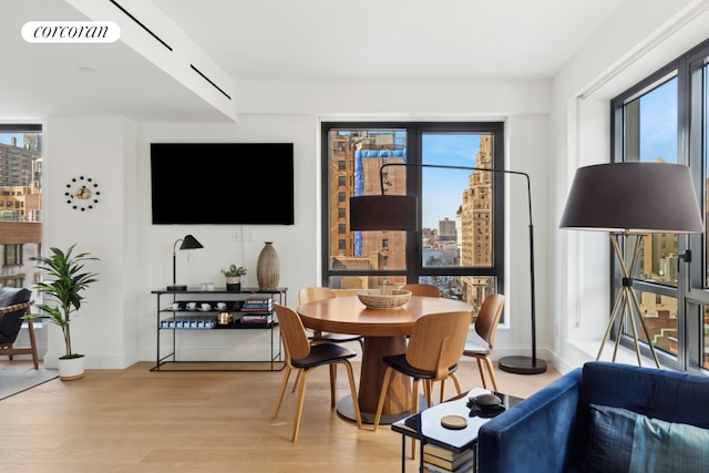 dining space featuring light wood-type flooring, baseboards, visible vents, and a wealth of natural light