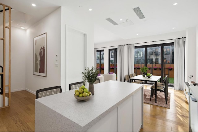 kitchen featuring light wood-style flooring, white cabinetry, and light countertops