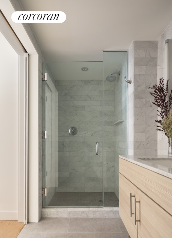 bathroom with vanity and a shower with door