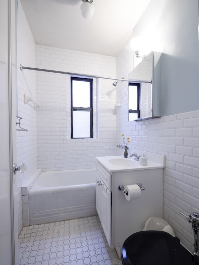 full bath with toilet, shower / washtub combination, vanity, and tile walls