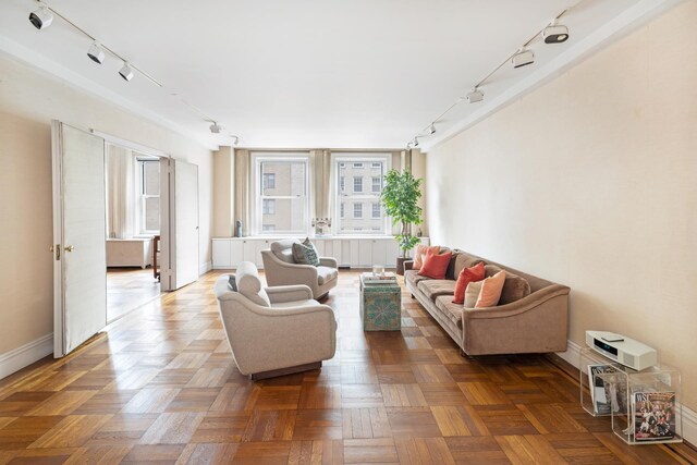 living room with rail lighting and baseboards