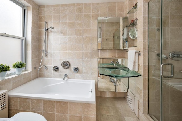 bathroom with shower with separate bathtub and tile walls