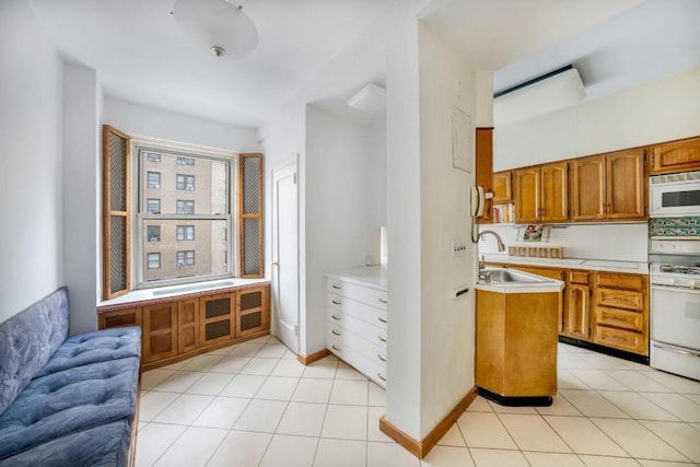 kitchen with sink, white appliances, and light tile patterned flooring