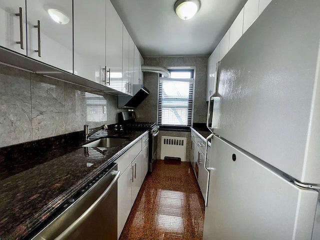 kitchen featuring radiator heating unit, appliances with stainless steel finishes, white cabinetry, a sink, and modern cabinets