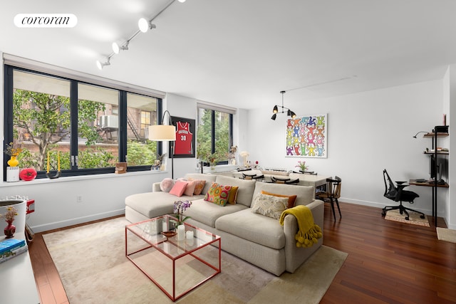 living room with rail lighting, wood-type flooring, visible vents, and baseboards