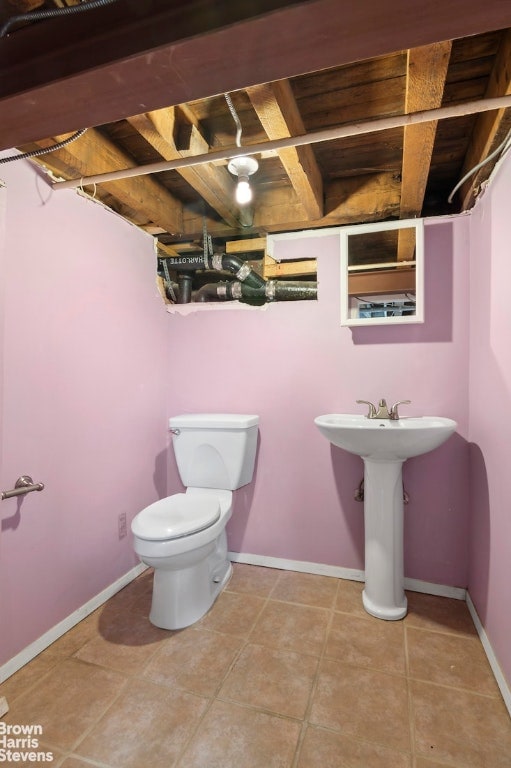 bathroom featuring toilet, tile patterned flooring, and baseboards