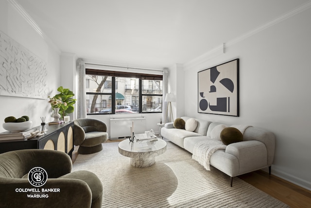 living area featuring ornamental molding, wood finished floors, radiator heating unit, and baseboards