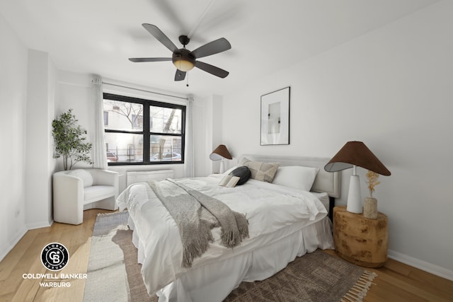 bedroom with wood finished floors, baseboards, and a ceiling fan