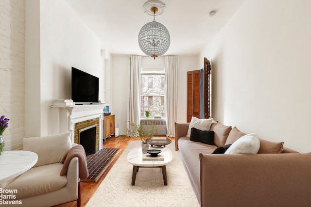 living room with a tiled fireplace and light hardwood / wood-style floors