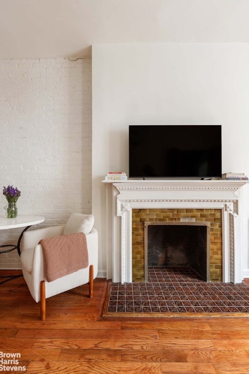 interior space featuring wood-type flooring and a tiled fireplace