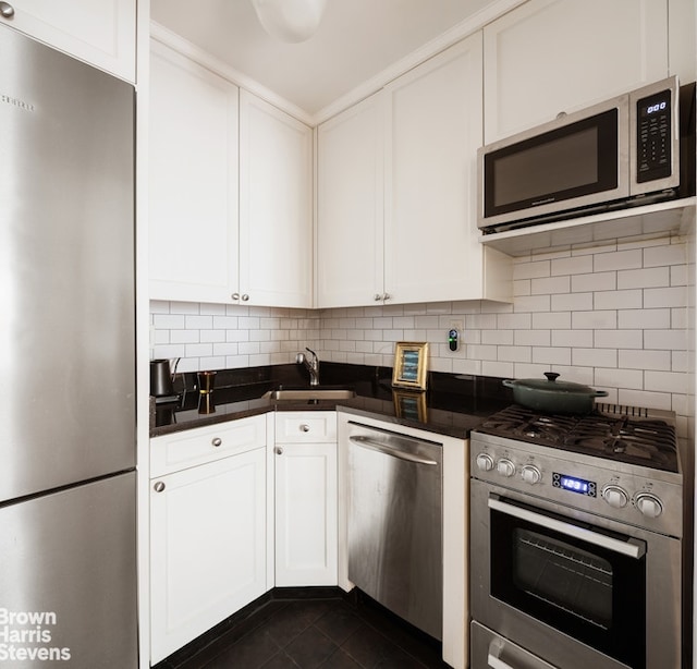 kitchen featuring tasteful backsplash, sink, white cabinets, and appliances with stainless steel finishes