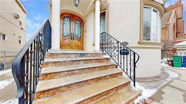 doorway to property with fence and stucco siding