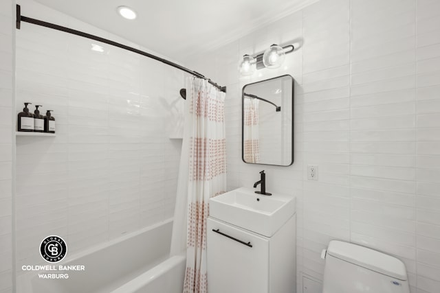 full bathroom with shower / bath combo with shower curtain, vanity, tile walls, and toilet