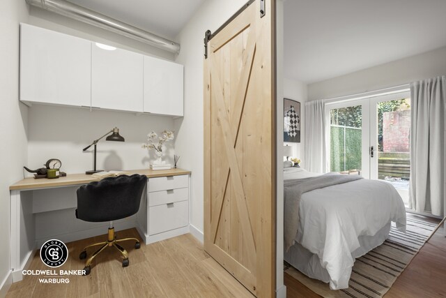 office featuring a barn door and light hardwood / wood-style flooring