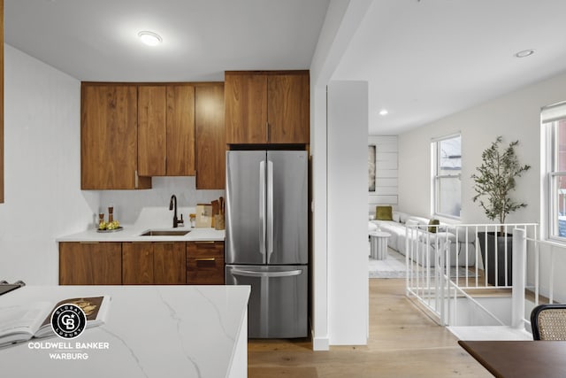 kitchen with sink, stainless steel refrigerator, and light hardwood / wood-style floors