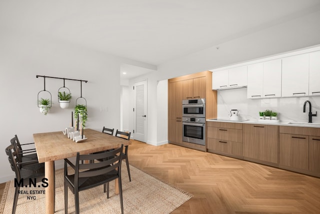 22-54 46th St Unit 201, New York City, NY 11105 - kitchen featuring double oven, baseboards, a sink, light countertops, and modern cabinets
