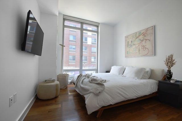 bedroom with dark wood-type flooring and multiple windows