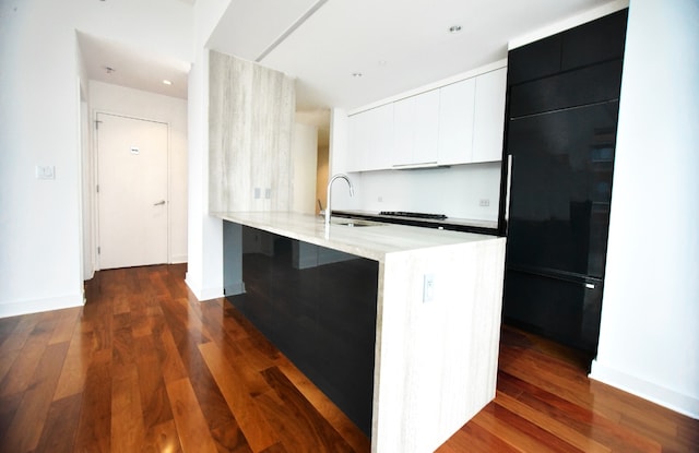 kitchen featuring white cabinetry, sink, dark wood-type flooring, and kitchen peninsula