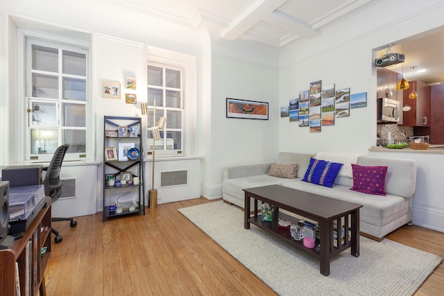 living area with beamed ceiling, coffered ceiling, visible vents, and light wood-style floors