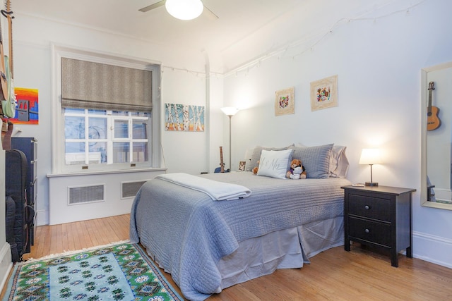 bedroom featuring a ceiling fan, wood finished floors, and visible vents