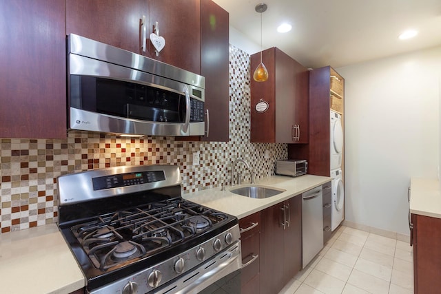 2109 Broadway Unit 902, New York City, NY 10023 - kitchen featuring stainless steel appliances, estacked washer and dryer, light countertops, tasteful backsplash, and pendant lighting
