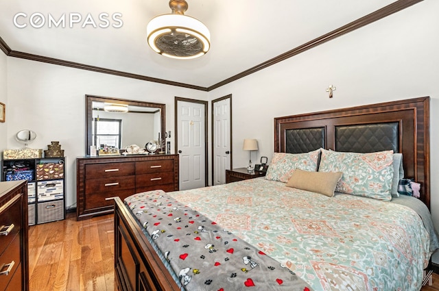 bedroom with light wood-style floors and crown molding