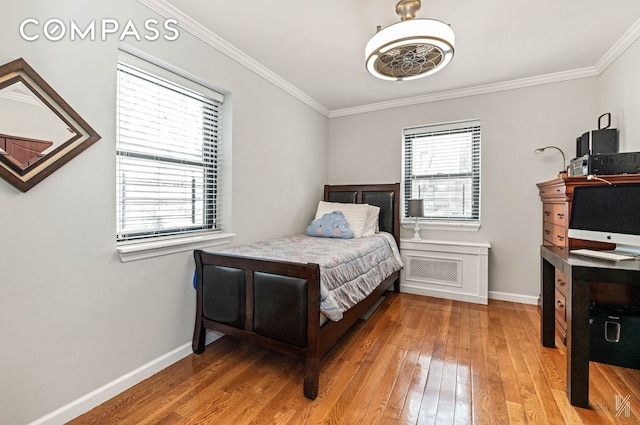 bedroom featuring baseboards, ornamental molding, and wood-type flooring