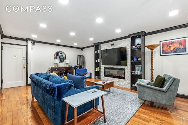 living area featuring recessed lighting, a barn door, ornamental molding, a stone fireplace, and wood finished floors