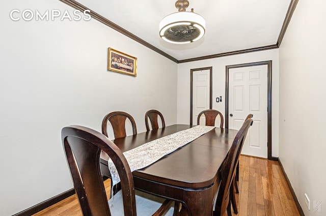 dining area with baseboards, ornamental molding, and light wood-type flooring