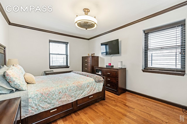 bedroom featuring baseboards, ornamental molding, and light wood finished floors