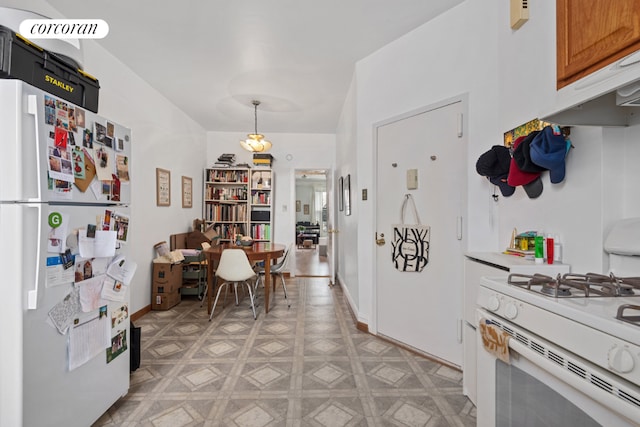 kitchen featuring white appliances, light floors, light countertops, under cabinet range hood, and pendant lighting