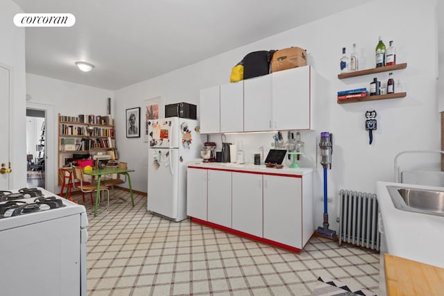 kitchen featuring radiator, light countertops, visible vents, white cabinets, and white appliances