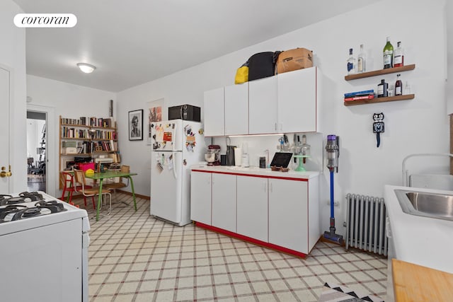 kitchen with radiator, visible vents, white appliances, white cabinets, and light floors