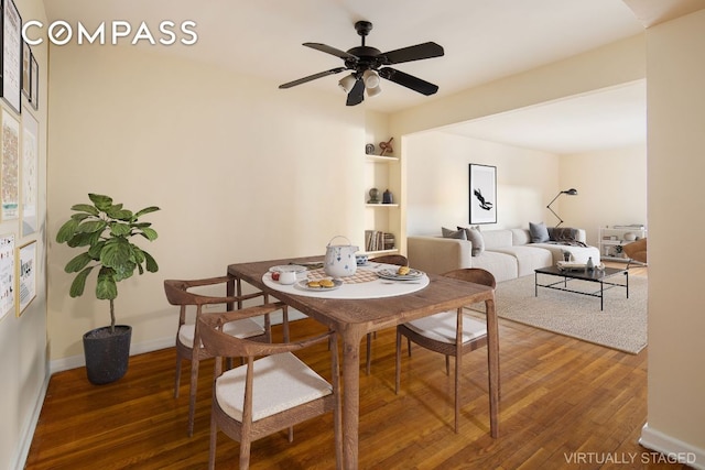 dining area with dark wood-type flooring, ceiling fan, and baseboards