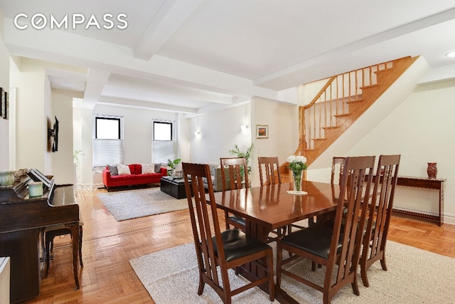 dining space with parquet floors and beam ceiling