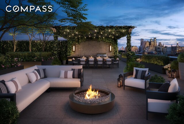 patio terrace at dusk with an outdoor living space with a fire pit, a city view, and outdoor dining space