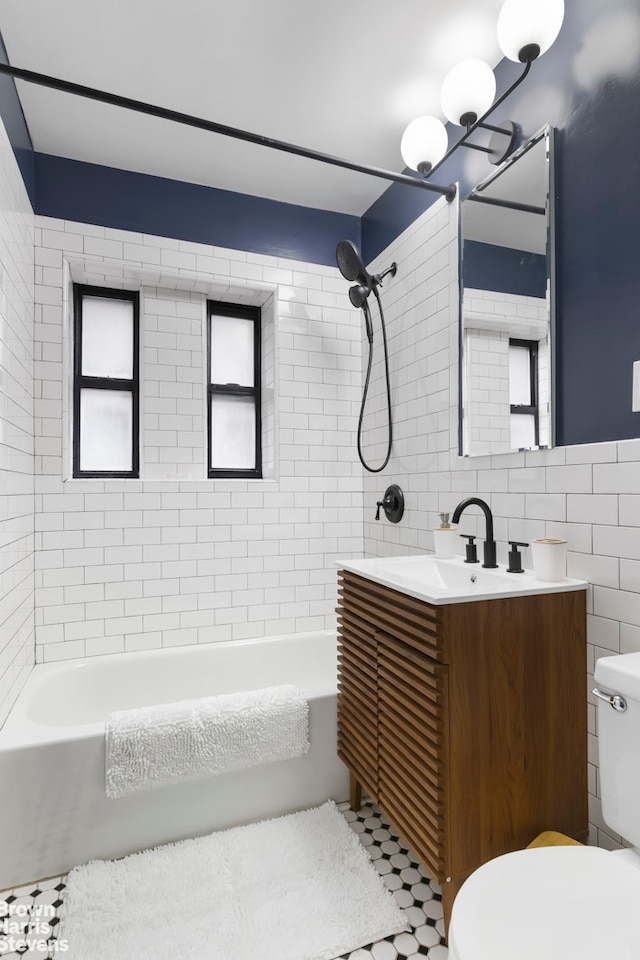 full bathroom featuring toilet, shower / tub combination, tile walls, and vanity