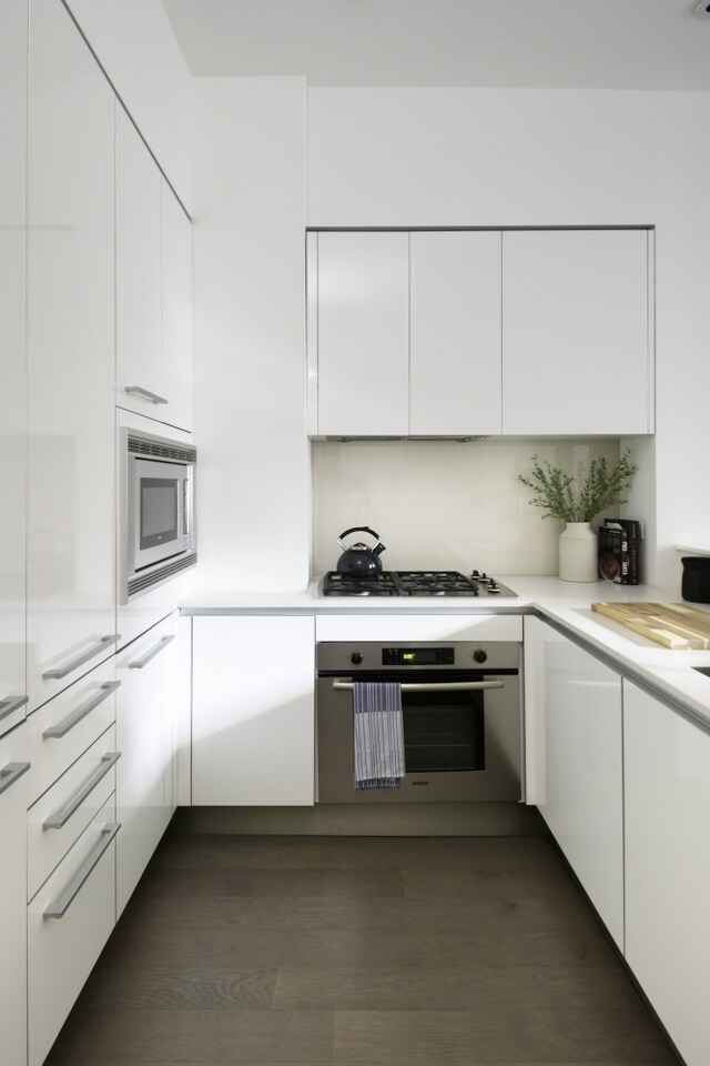 kitchen with white cabinetry, modern cabinets, appliances with stainless steel finishes, and light countertops