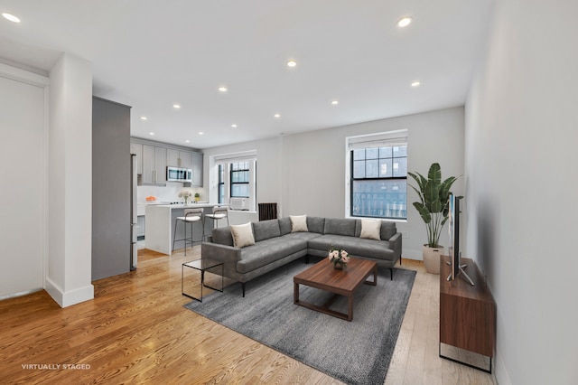 living room featuring plenty of natural light, light wood-style flooring, and recessed lighting