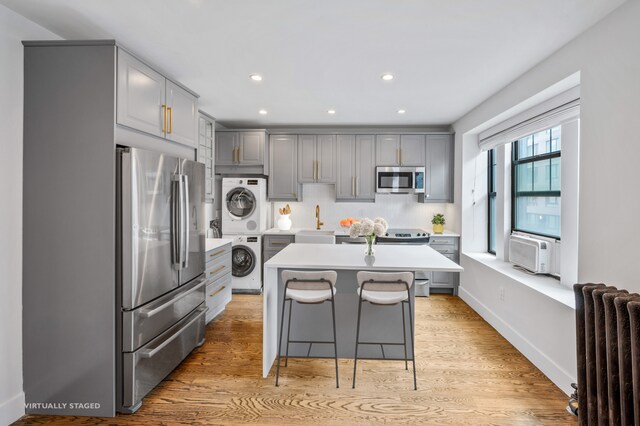 living area with plenty of natural light, recessed lighting, light wood-type flooring, and baseboards