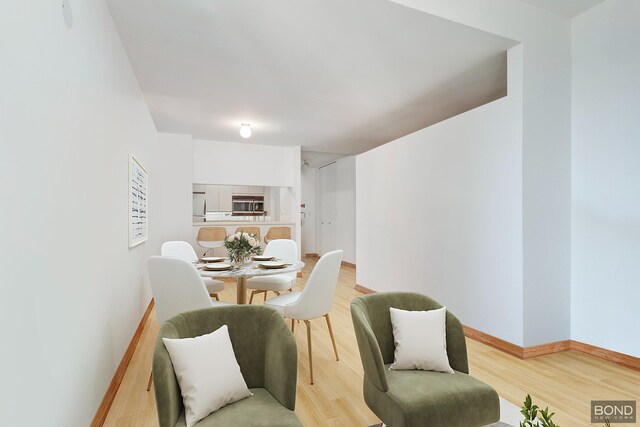 dining space with baseboards and light wood-style floors