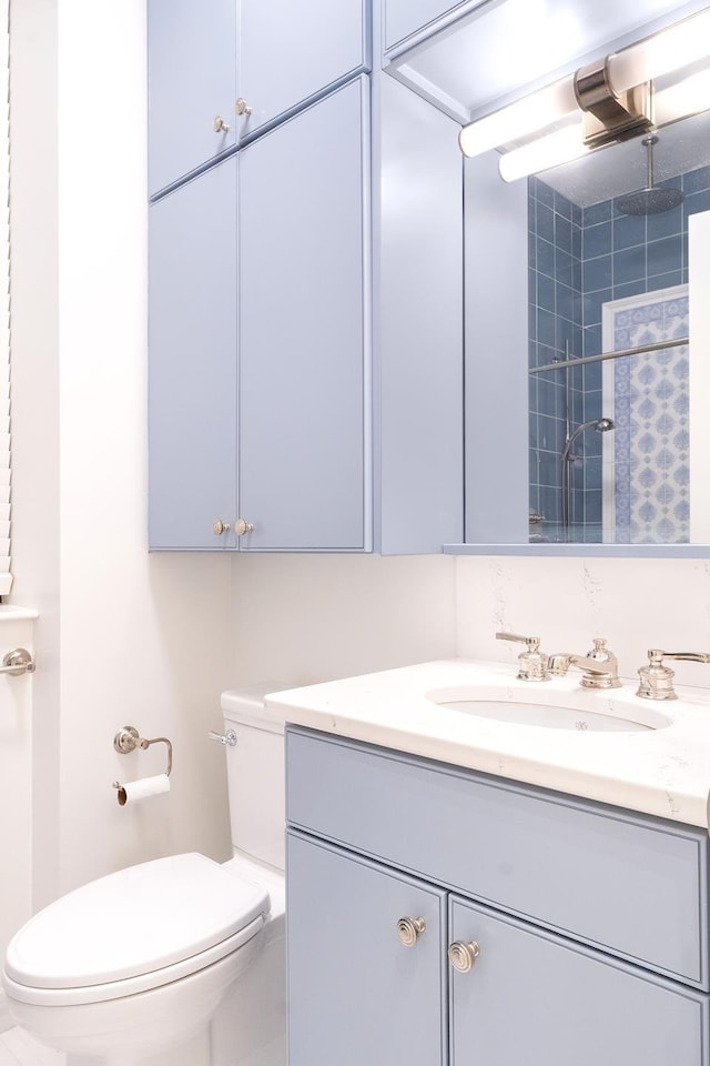 bathroom featuring a shower, toilet, and vanity