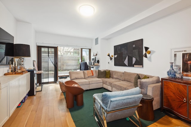 living area featuring light wood-style floors and visible vents