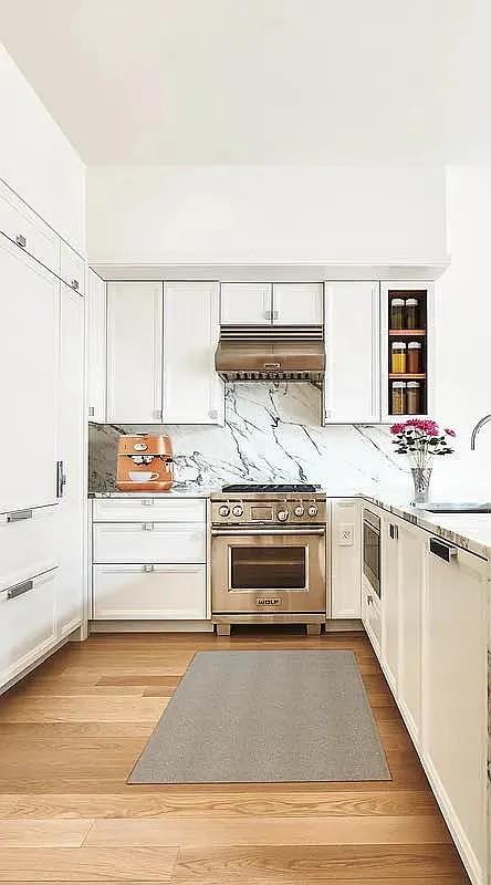 kitchen with stainless steel appliances, light countertops, light wood-style floors, a sink, and under cabinet range hood