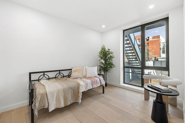 bedroom with access to exterior and light hardwood / wood-style floors