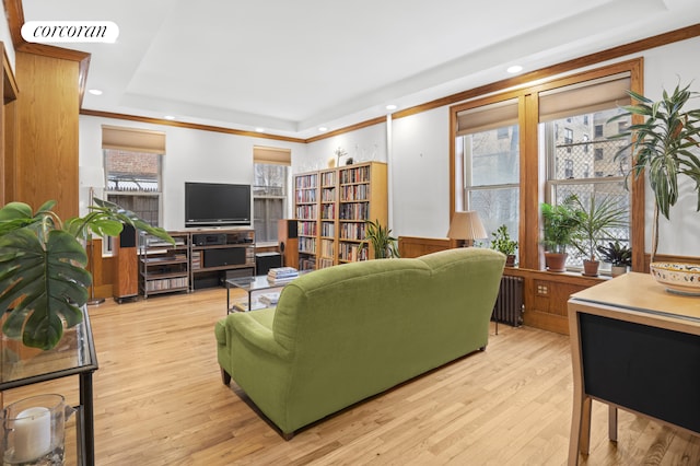 living room with recessed lighting, radiator heating unit, a raised ceiling, and light wood-type flooring