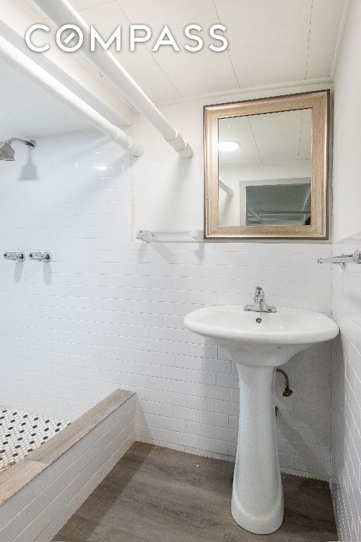 bathroom with sink, tile walls, and hardwood / wood-style floors