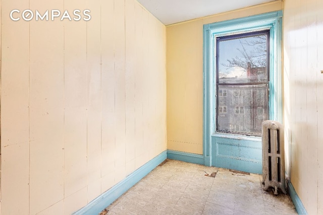 unfurnished room with radiator and a wealth of natural light